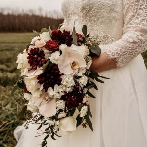 A bride holding her bouquet in the field