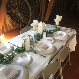 A table set with plates and napkins, candles and flowers.
