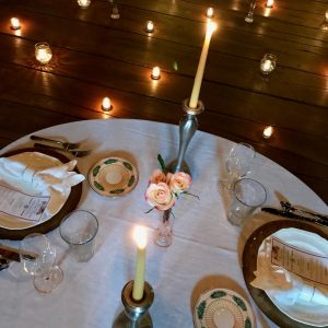 A table set with candles and plates on it.